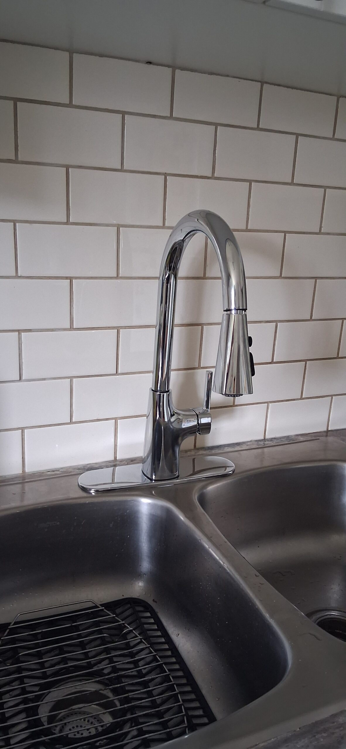 Handyman repairing a leaking kitchen faucet at a sink in Ottawa