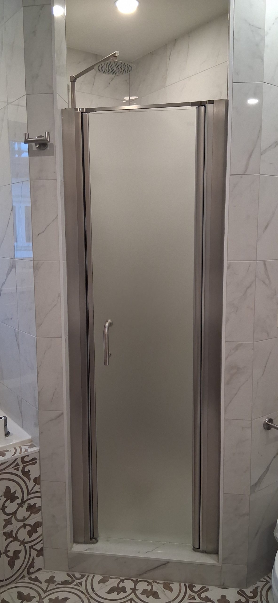 Fresh clear sealing applied along a shower glass panel and door edge in Ottawa after removal of worn sealing material.