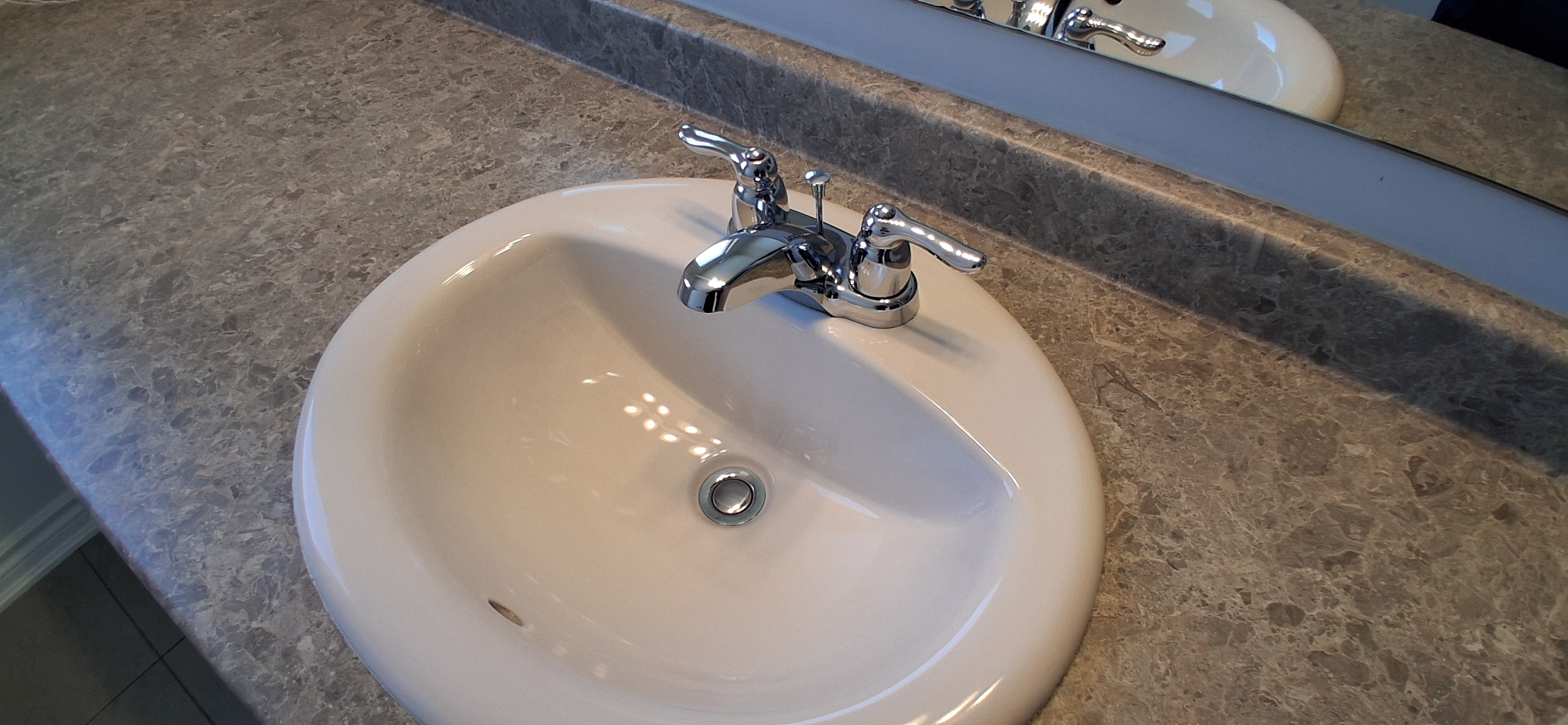 Fresh white caulking applied neatly between a sink and countertop edge in Ottawa after removal of worn sealant.