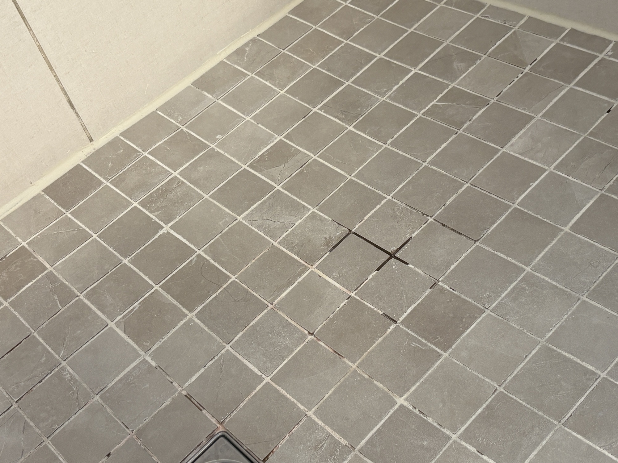 Damaged shower grout before repair